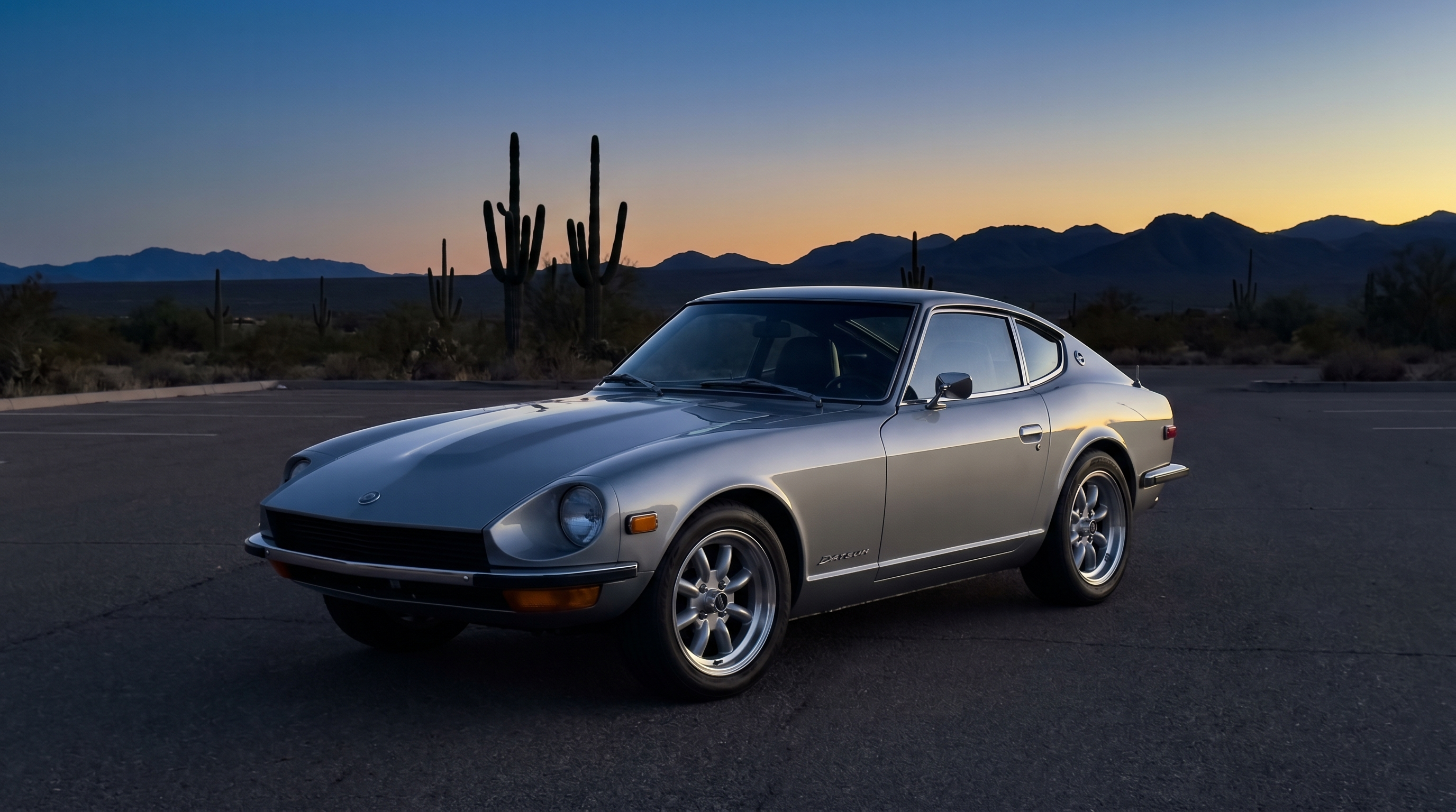 Restomod Datsun 240Z with a new OEM-pattern windshield at a desert overlook at blue hour
